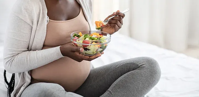 Mulher grávida comendo salada Mulher grávida comendo salada