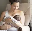 Mère allaitant son bébé dans un fauteuil.