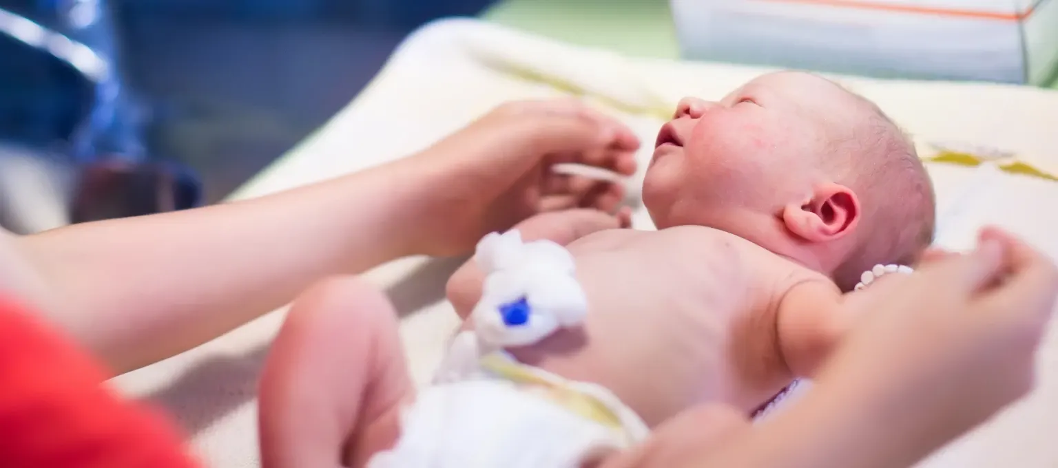 Mamá cambiando pañal a su guagua prematura Mamá cambiando pañal a su guagua prematura