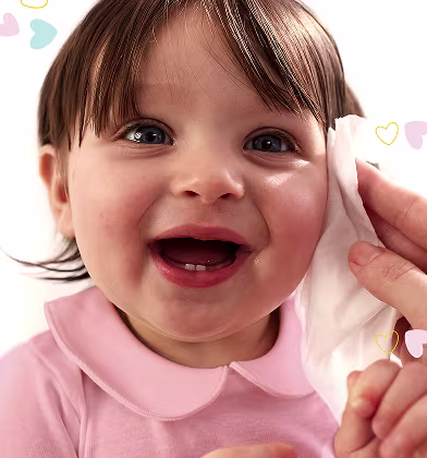 Zbliżenie na twarz niemowlęcia, gdy ręka delikatnie wyciera jego policzek chusteczką Pampers Sensitive. Zbliżenie na twarz niemowlęcia, gdy ręka delikatnie wyciera jego policzek chusteczką Pampers Sensitive.