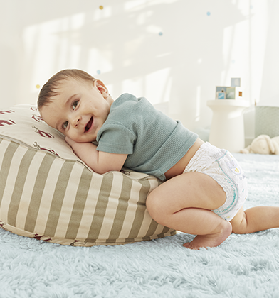 Un bebé que lleva un pañales-braguita está a cuatro patas.