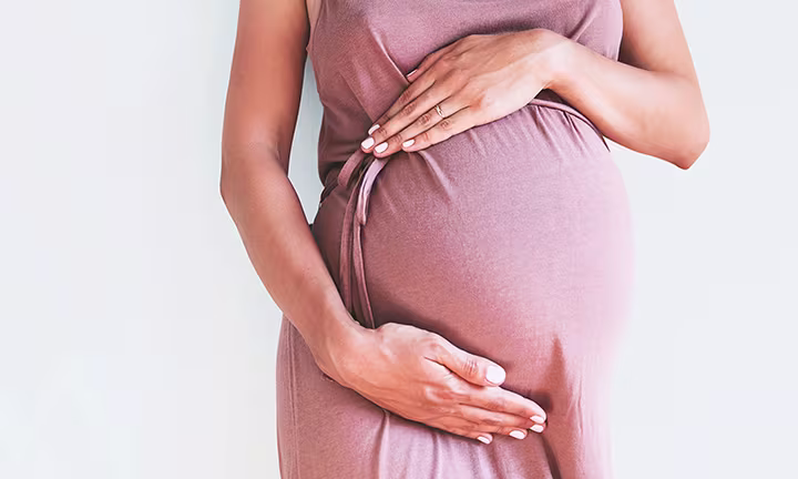 Mulher grávida com a mão na barriga