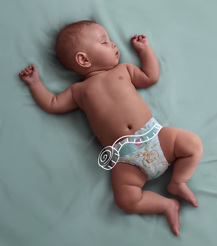 Baby slaapt in het bed, met een liniaal op de rand van de luier.