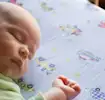 Jak zapobiegać SIDS? Niemowlę śpiące w łóżeczku