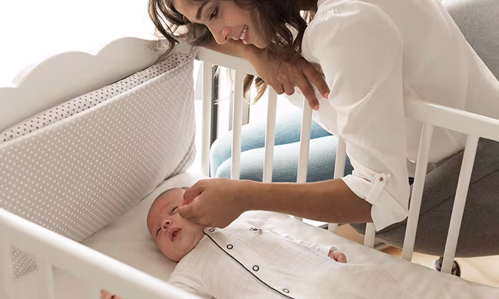 Baby schläft in Krippe auf dem Rücken