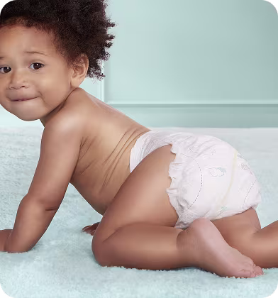 Un copil care merge de-a bușilea în scutec Pampers Premium Care