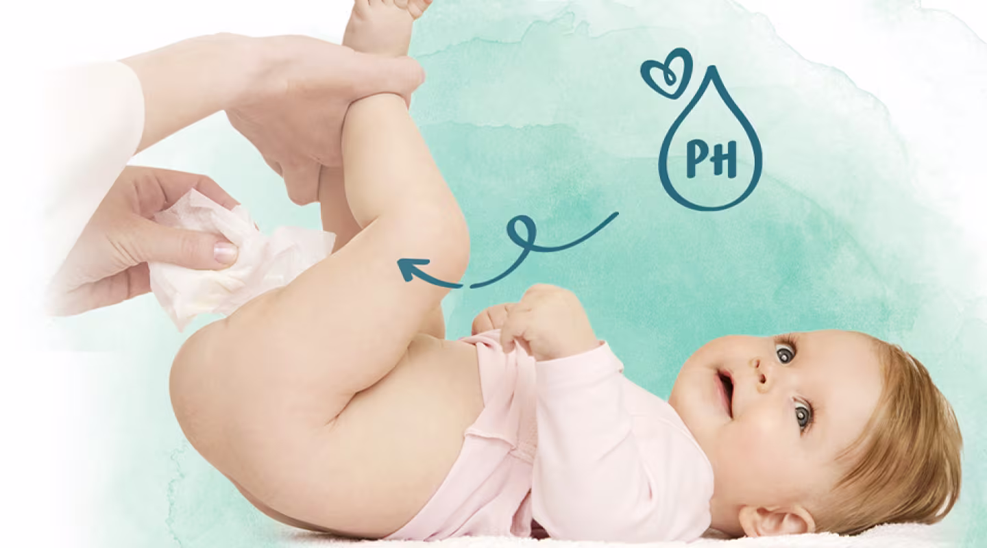 Un bebé está tumbado de espaldas mientras una persona le limpia el trasero con una toallita.