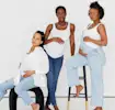 Three pregnant women posing with hands on bellies and looking confidently into the camera