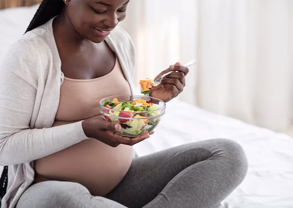 Mulher grávida comendo salada