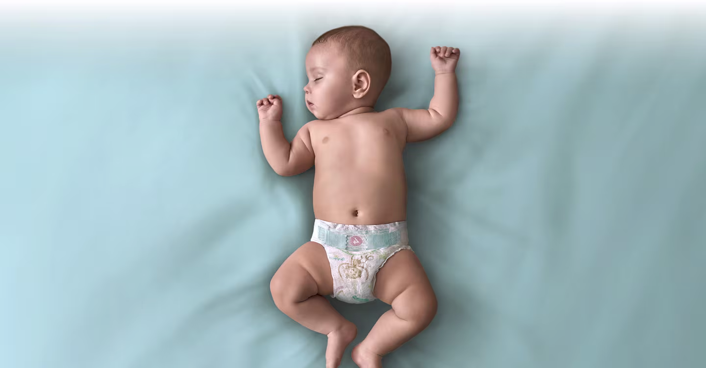 Bebelușul doarme liniștit pe păturica albastră.