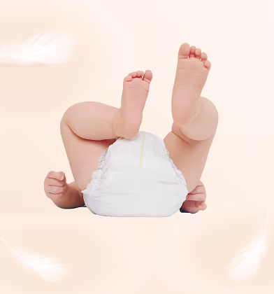 Un bebé que lleva un pañal Dodot está tumbado de espaldas con las piernas en el aire.