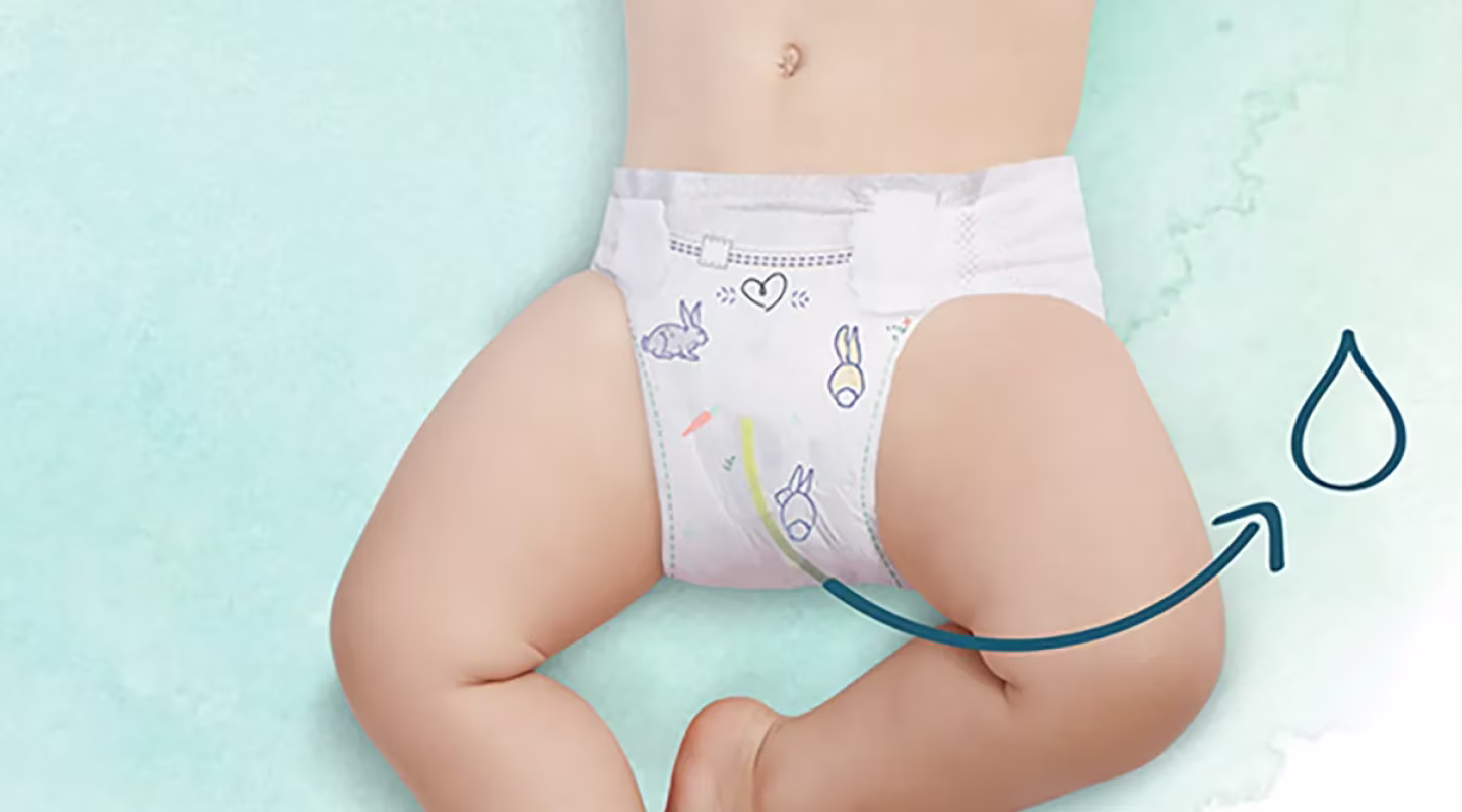 Mostra-se o torso inferior e as pernas de um bebé visto de cima, deitado sobre uma superfície de cor verde claro. A fralda Dodot destaca um indicador de humidade.