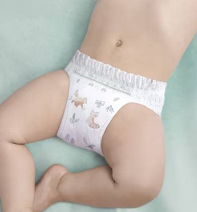 A baby's lower torso and legs are shown from an overhead view, lying on a light green surface.The Pampers nappy has a stretchy waistband and nice graphics