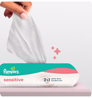 Un gros plan montre une main tirant une lingette Pampers Sensitive hors de son emballage. Un gros plan montre une main tirant une lingette Pampers Sensitive hors de son emballage.