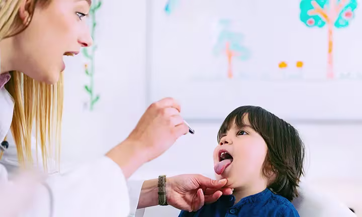 Banner image of a toddler receiving a medical check-up for strep throat
