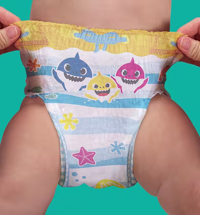 Дві долоні розтягують боки купальної пелюшки з малюнком Baby Shark на нижній частині тіла дитини, показуючи еластичний пояс і повний візерунок. Дві долоні розтягують боки купальної пелюшки з малюнком Baby Shark на нижній частині тіла дитини, показуючи еластичний пояс і повний візерунок.