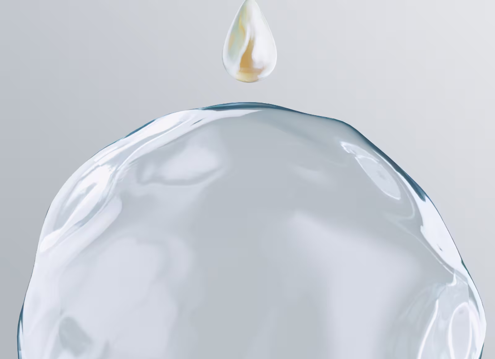 O picătură strălucitoare, aurie, de loțiune plutește deasupra unei picături de apă limpede și curată.