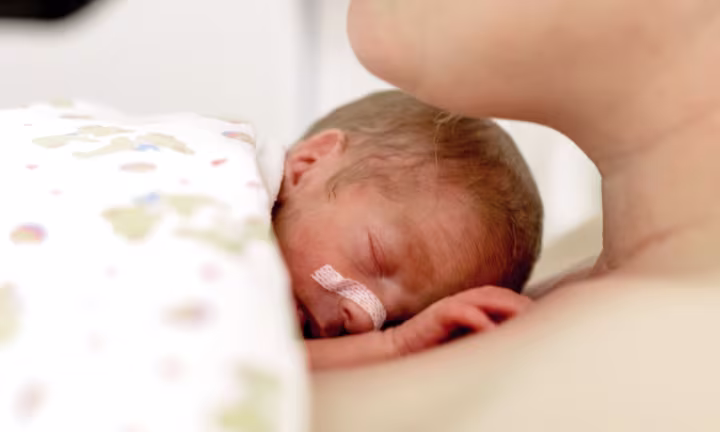Frühgeborenes Baby liegt auf seiner Mutter