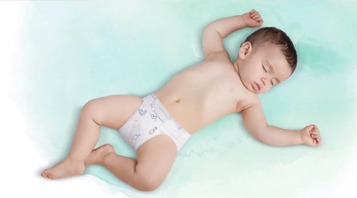 Un bebé durmiendo de espaldas, con un pañal Dodot.