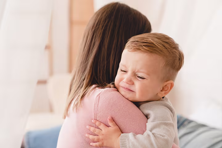  Νήπιο που κλαίει στην αγκαλιά γυναίκας​