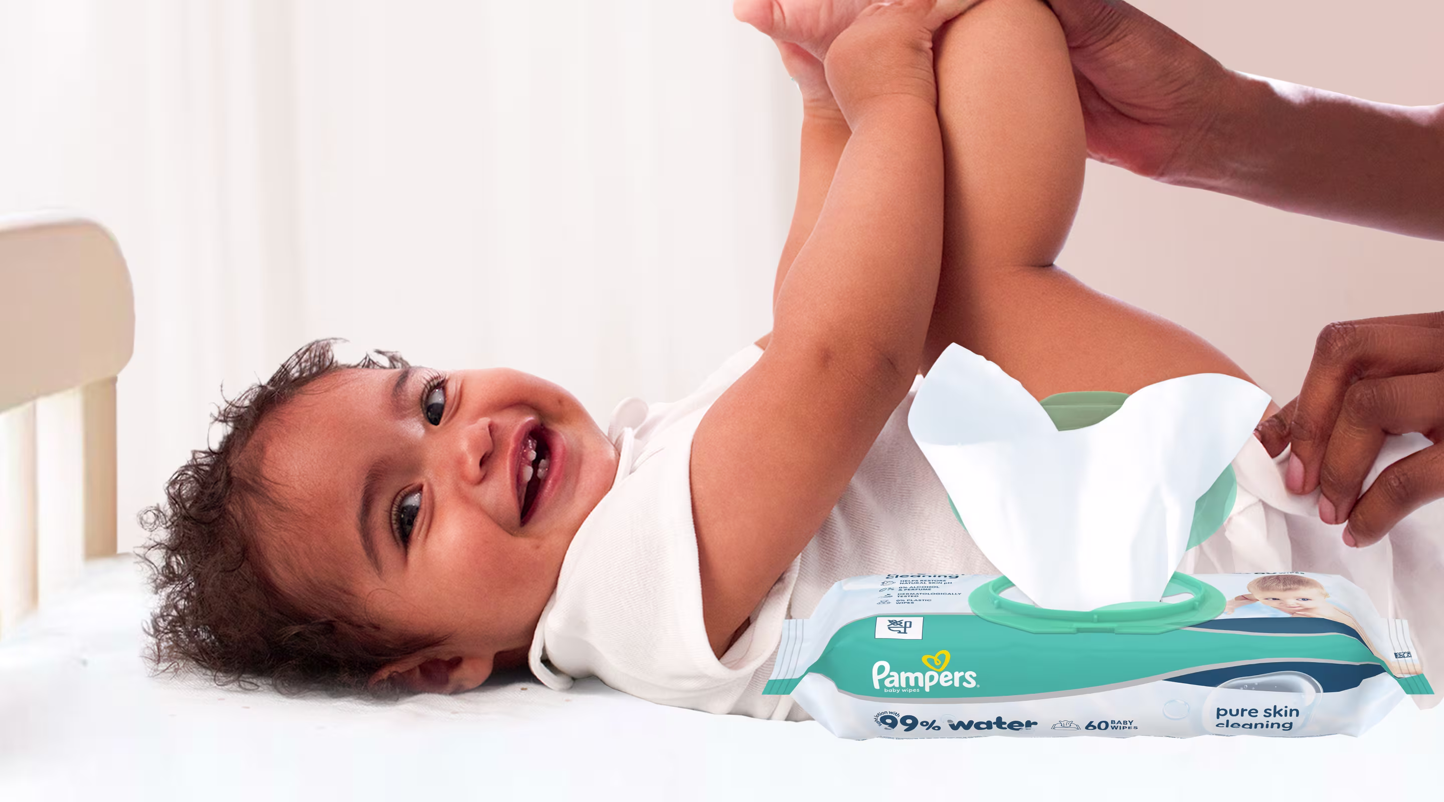 Baby liegt auf dem Rücken und wird sanft mit einem Feuchttuch gereinigt.