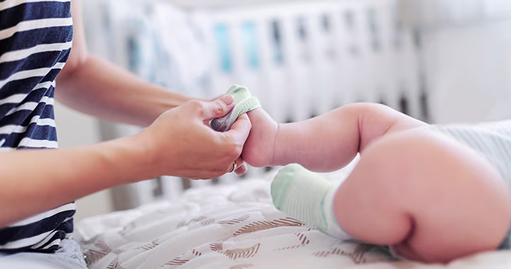 Mutter zieht Baby Socken an