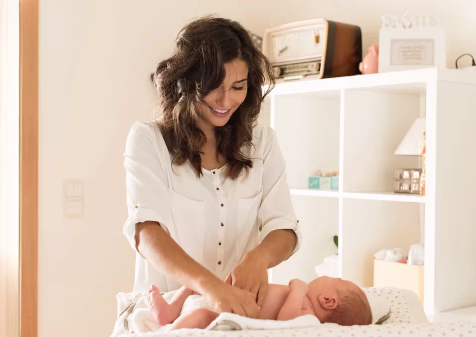 Mamá cambiando pañal a su bebé