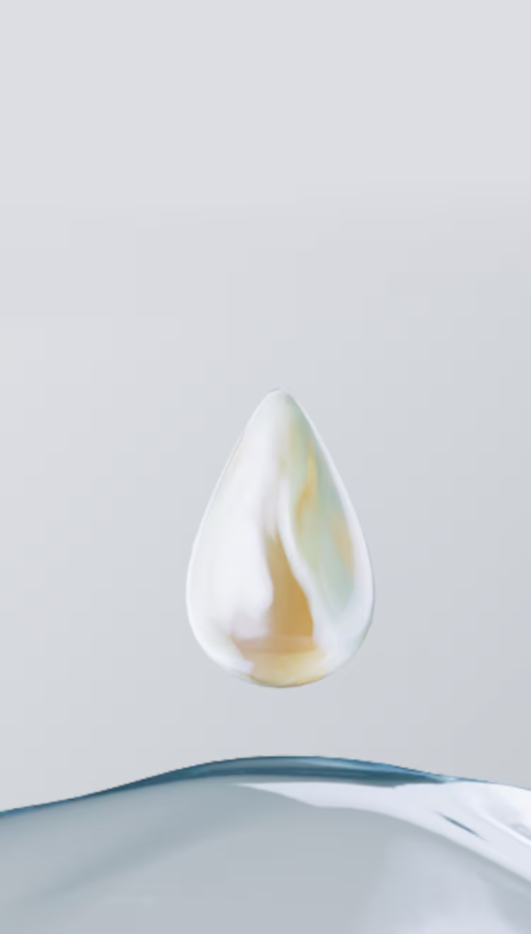 Uma gota de soro dourada e brilhante está suspensa sobre uma gota de água clara e pura.