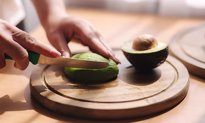 Schwangere Frau bei Zubereitung von Avocado
