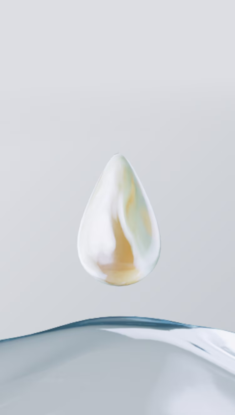 Ein glänzender, goldener Tropfen Lotion schwebt über einem klaren, reinen Tropfen Wasser.