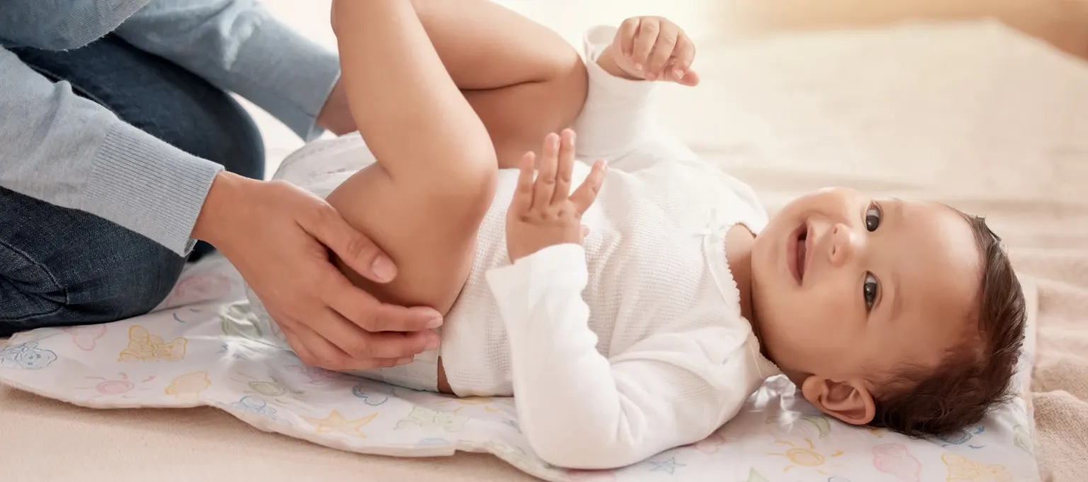 Mamá cambiando pañal a su bebé con piel sensible