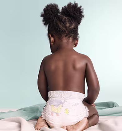 A baby from behind wearing a Premium Protection nappy A baby from behind wearing a Premium Protection nappy