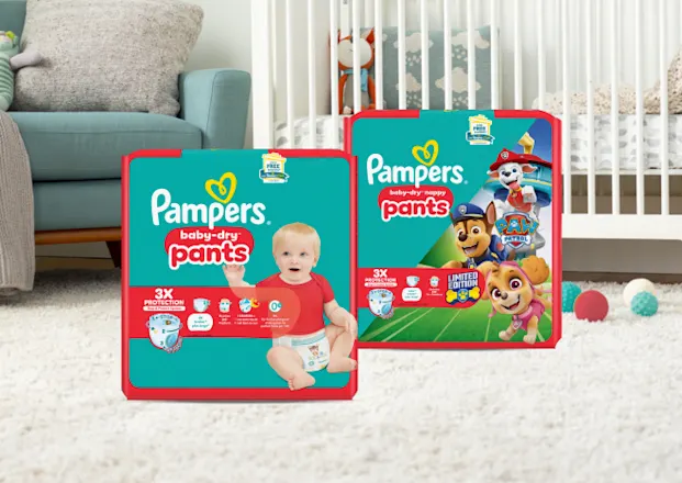 Pampers Baby-Dry Pants und Baby-Dry Paw Patrol Pants Packungen in einem Babyzimmer.