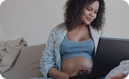 Pregnant mom doing research on laptop