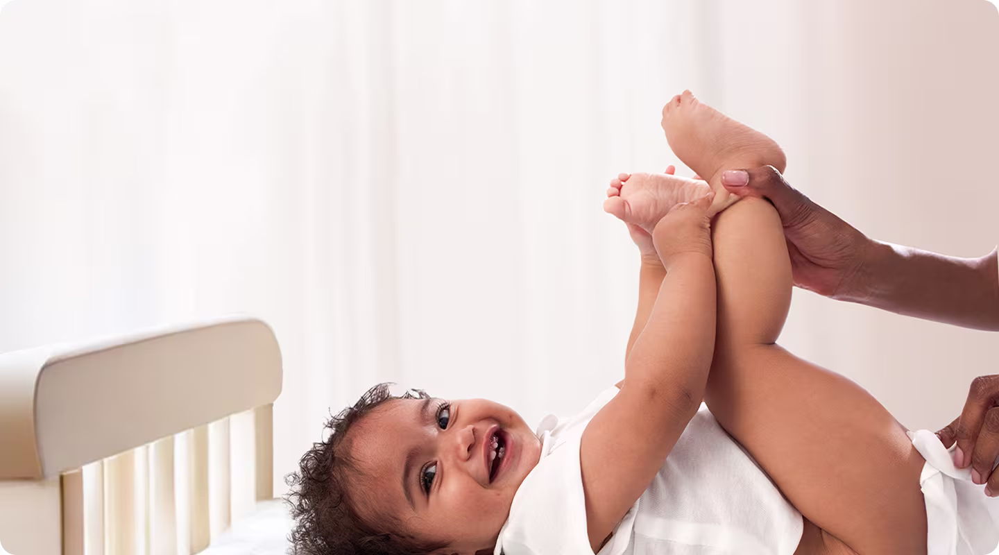 Le bébé est allongé sur le dos et est délicatement nettoyé avec une lingette humide.