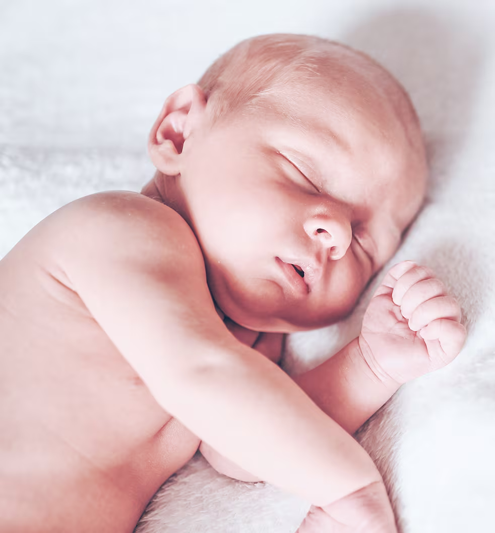 Sleeping newborn baby lying on a soft blanket.