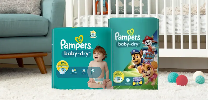 Pampers Baby-Dry und Pampers Baby-Dry Paw Patrol Packung in einem Babyzimmer.
