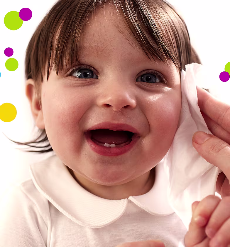 Eine Nahaufnahme des Gesichts eines Babys, während eine Hand sanft die Wange mit einem Pampers Fresh & Clean Feuchttuch reinigt. Eine Nahaufnahme des Gesichts eines Babys, während eine Hand sanft die Wange mit einem Pampers Fresh & Clean Feuchttuch reinigt.