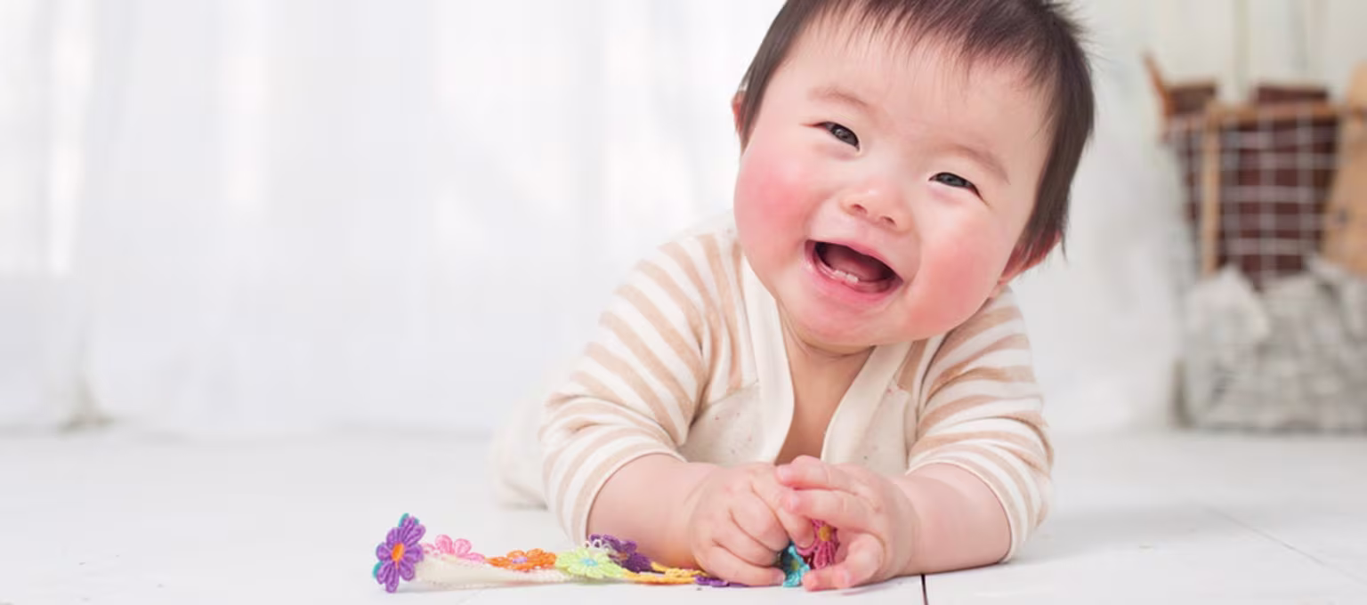 Baby smiling and playing with toy