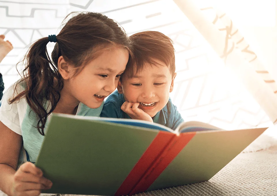 Crianças com livro sobre lendas do folclore brasileiro