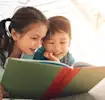 Crianças com livro sobre lendas do folclore brasileiro
