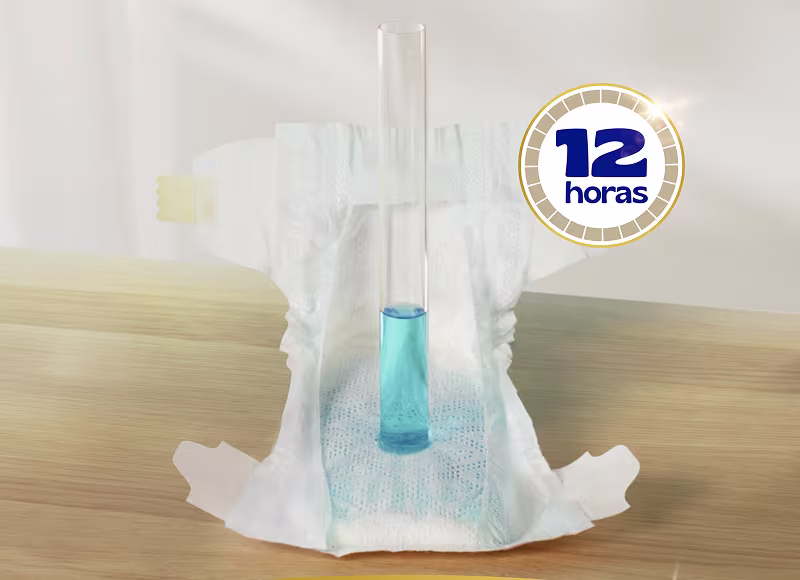 Mostra-se uma fralda com um tubo de ensaio que contém um líquido azul colocado dentro, demonstrando a capacidade de absorção da fralda.