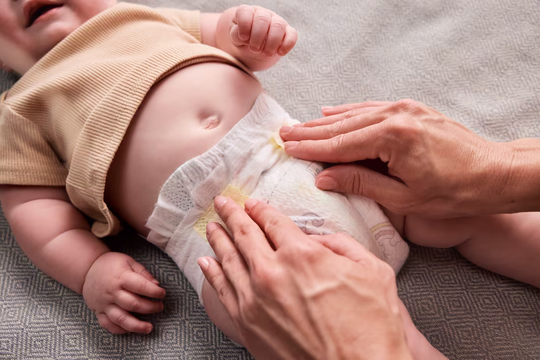 Ein Erwachsener wechselt einem Baby liebevoll die Windel