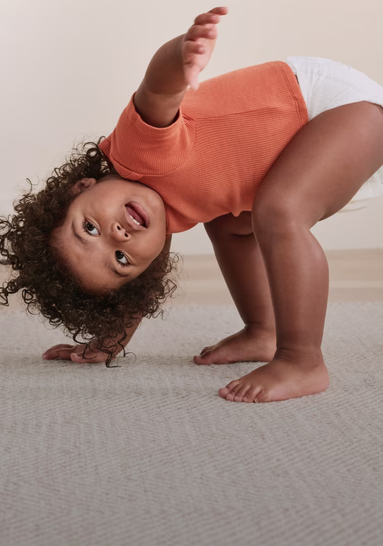 Toddler playing in nursery showing the flexible fit of a Pampers diaper