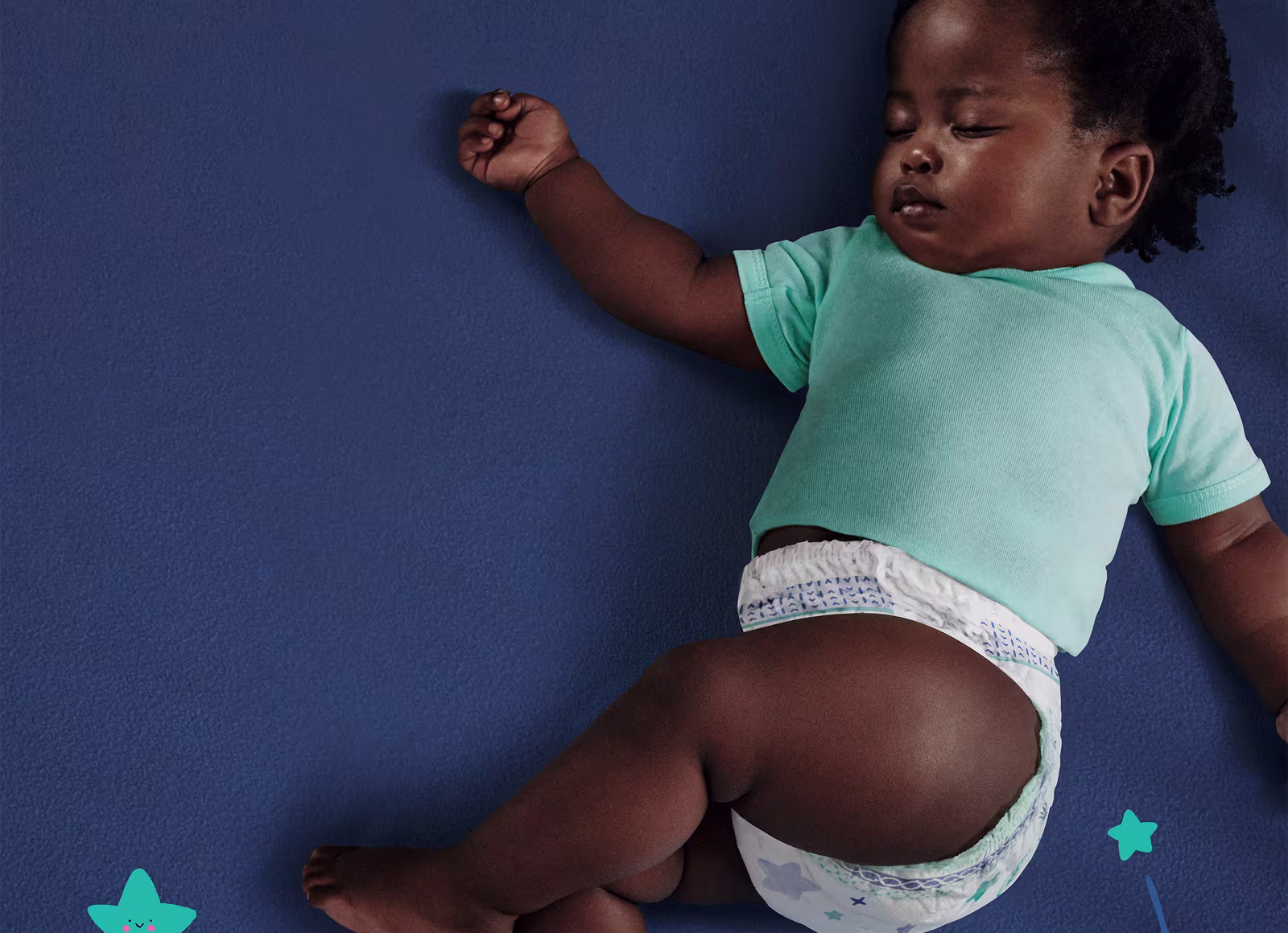 Ein Kind, das ein hellblaues T-Shirt und eine Pampers Pants trägt, schläft friedlich auf einer dunkelblauen Decke.
