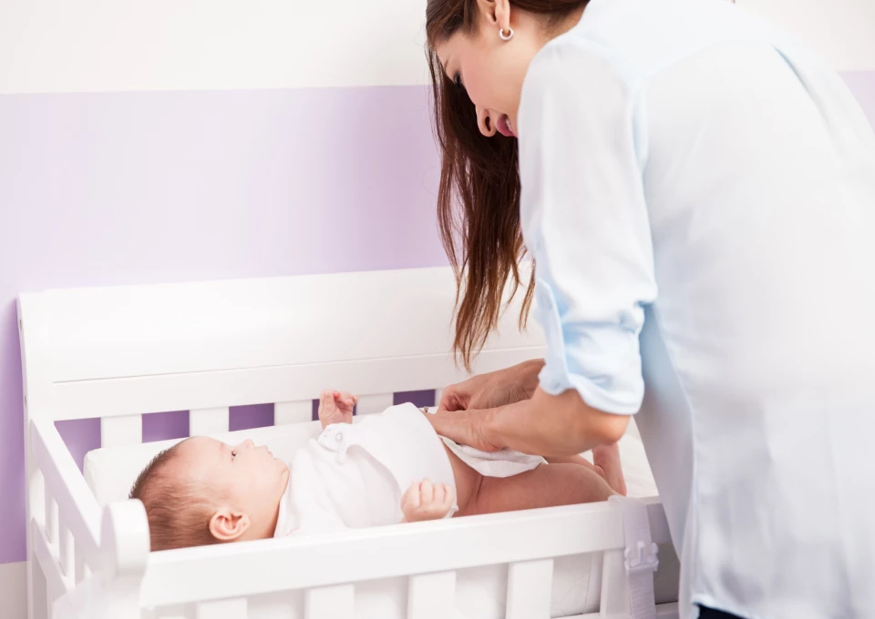 Mamá previniendo filtraciones de pañal a su bebé