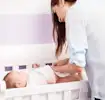 Mamá previniendo filtraciones de pañal a su bebé