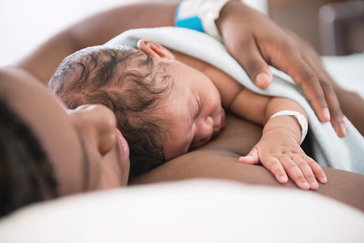 Newborn baby laying skin-to-skin with mom in the hospital