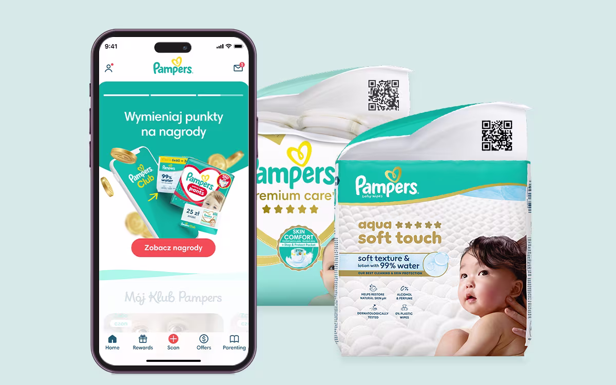 Aplikacja Pampers Club z widocznym saldem punktów, w tle pieluszki Pampers
