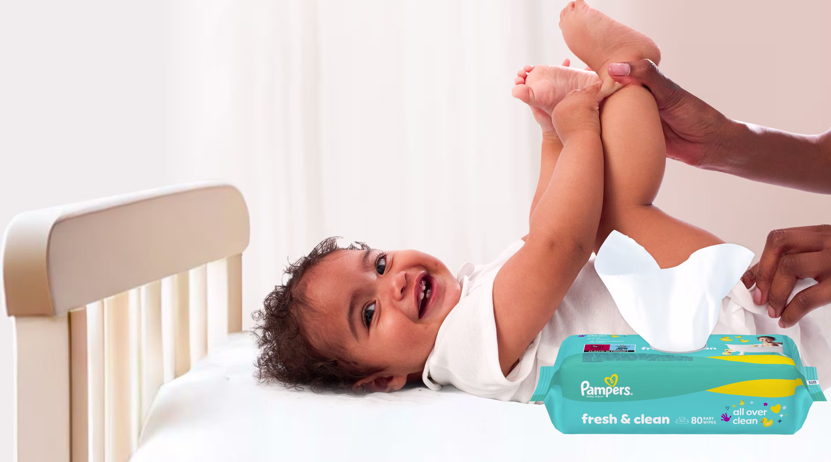 Baby liegt auf dem Rücken und wird sanft mit einem Feuchttuch gereinigt.